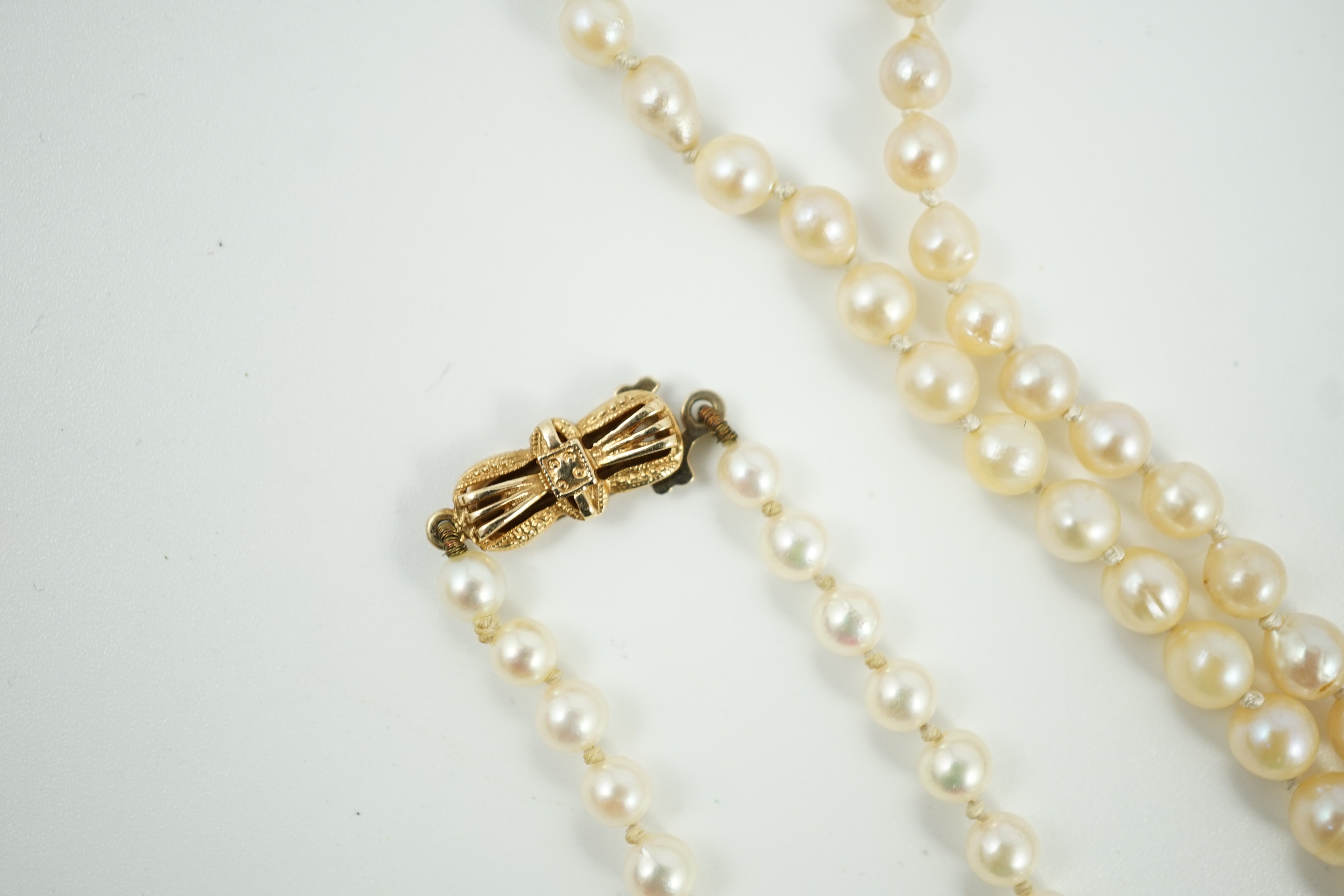 A twin strand graduated cultured pearl necklace, with white metal and two colour paste set clasp, 40cm, a single strand cultured pearl necklace, with 9ct gold clasp and a similar bracelet.